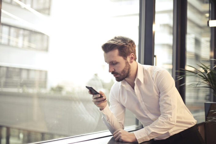 Man in formal attire looking at his phone