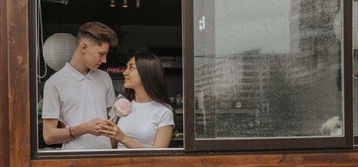 Romantic couple interacting against window in cafe