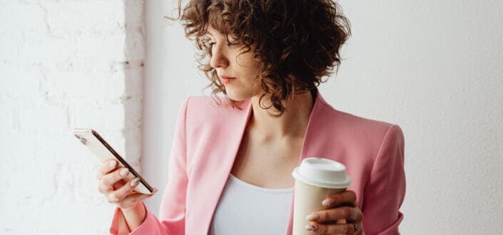 Woman in pink suit using a cellphone