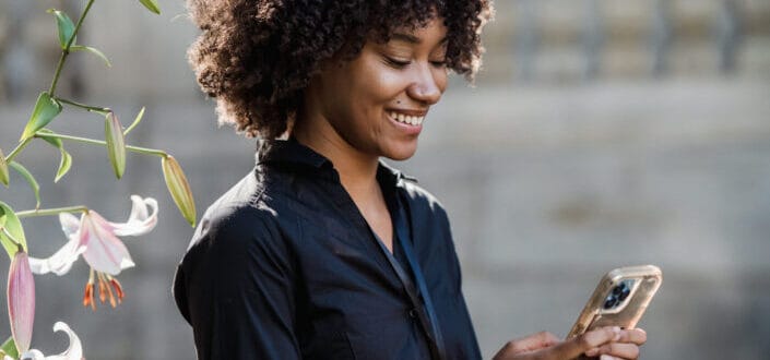 Woman smiling at her phone while texting