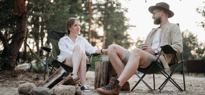A couple sitting on folding chairs while having conversation