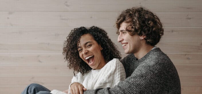 Happy Couple Sitting Close Together on the Floor