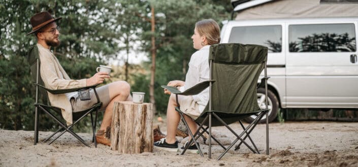 couple having conversation while sitting on folding chairs