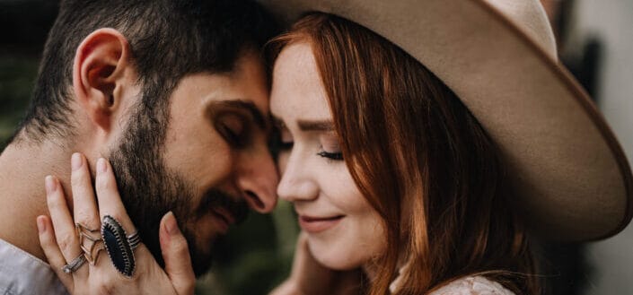 A Woman in Brown Hat Touching a Man Face