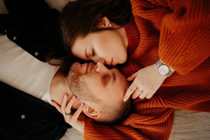 Couple laying opposite each other with heads together