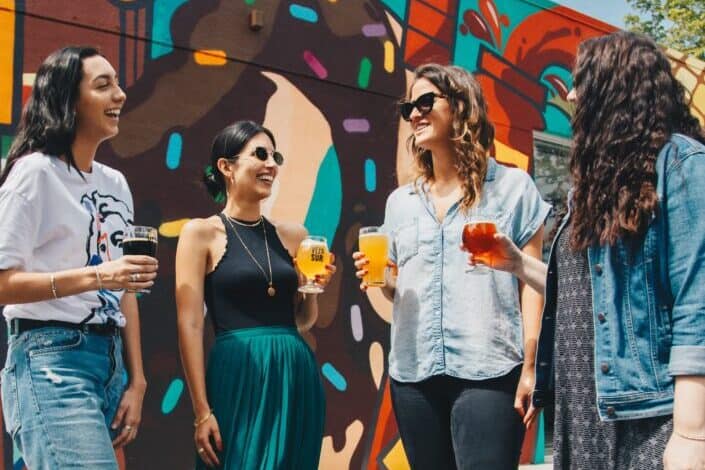 Group of Women Standing Near Decorated Wall