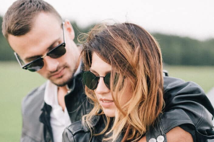 man cuddling his girlfriend in sunglasses