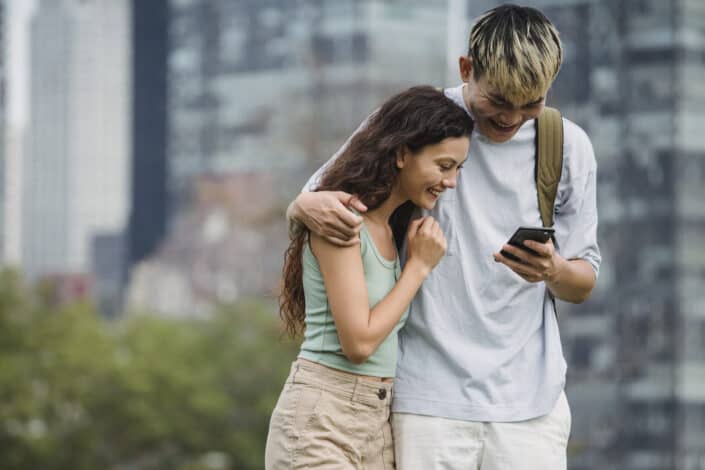 Couple Watching Smartphone on City Street