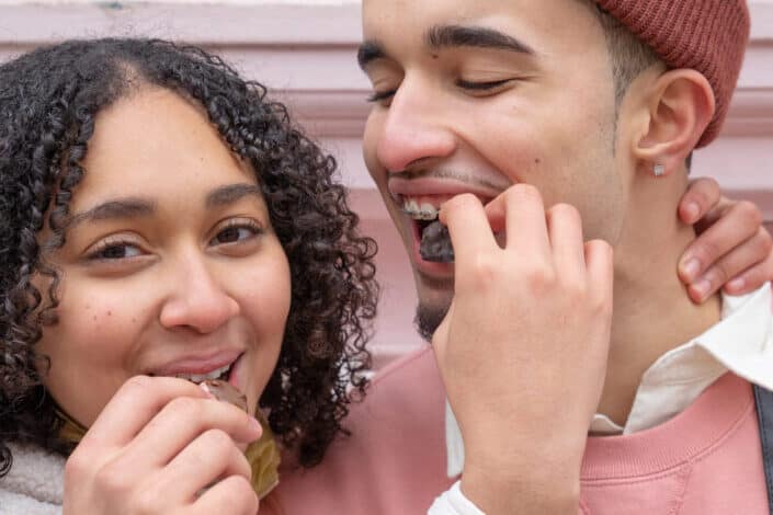 young couple feeding each other with chocolates