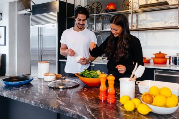 man and woman preparing salad