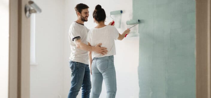 Man and woman painting the wall