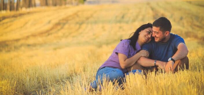 Man and woman sitting on grass field