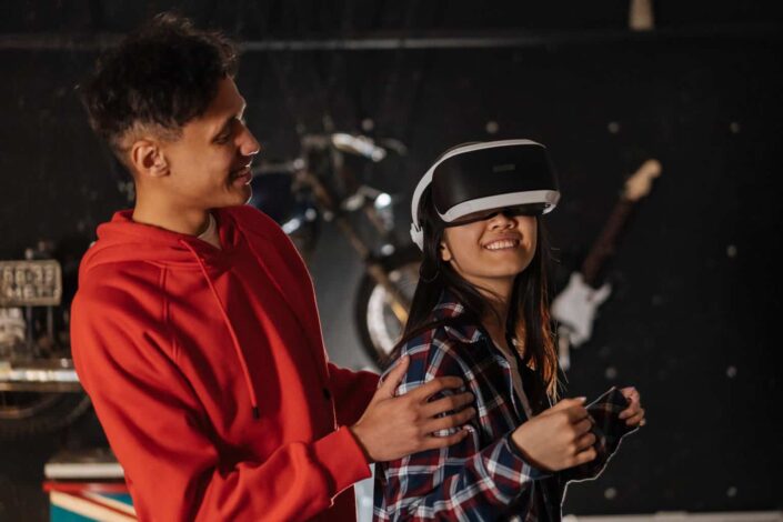 Man assisting his friend while using virtual reality goggles