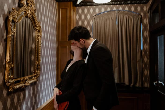 Man in Black Suit Kissing Woman in Black Dress