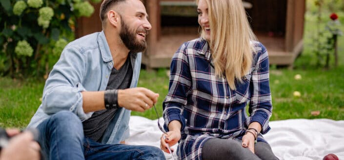Man in blue shirt sitting beside woman