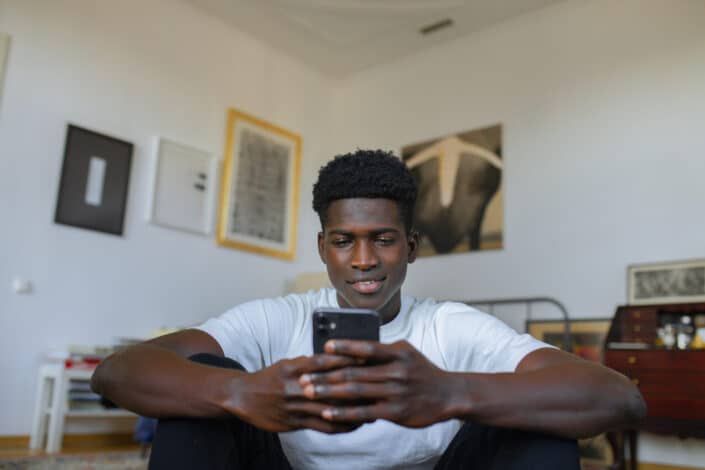 Man sitting in the room using smartphone
