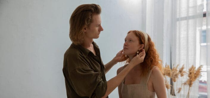 Man touching girlfriends face standing with hands in clay