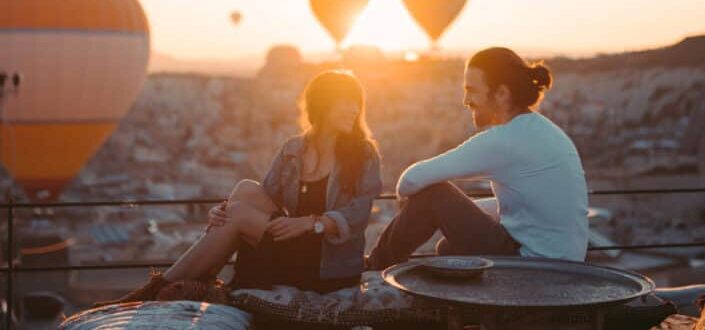 couple sitting on rooftop during sunset