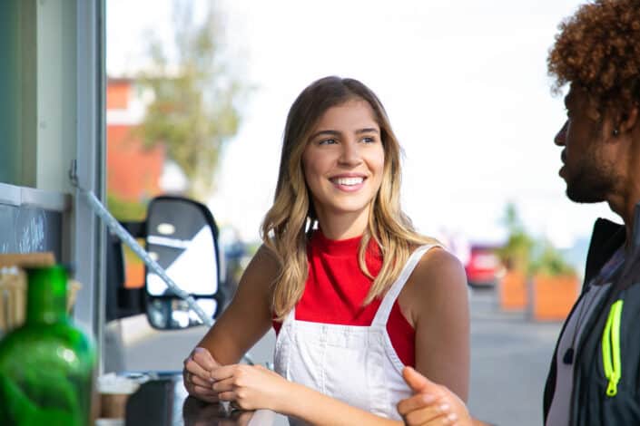 Positive female talking to black boyfriend near food truck