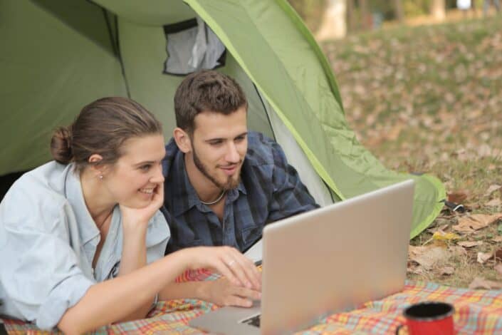 man and woman using laptop together
