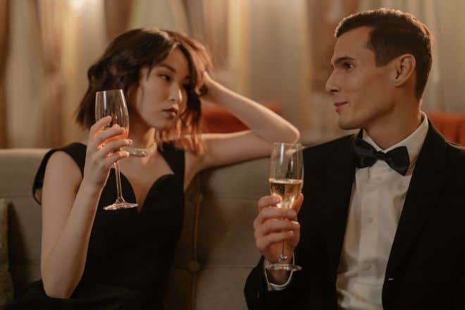 couple talking to each other while drinking champagne - Romantic questions to ask a guy on a date
