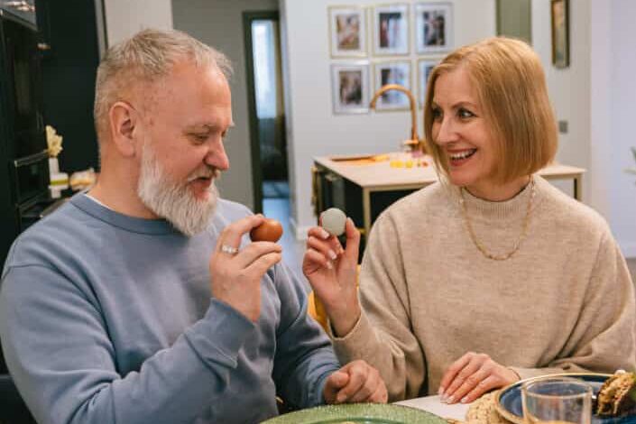 Smiling elderly couple holding easter eggs