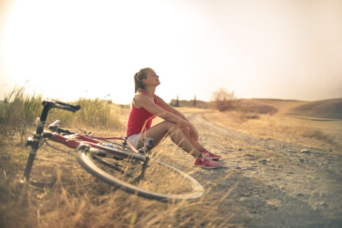 Woman With Bicycle Resting on Countryside Road