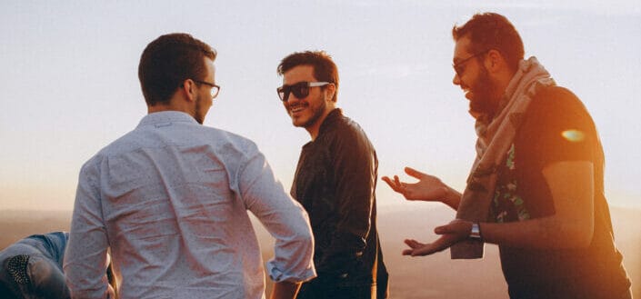 Three men standing while laughing