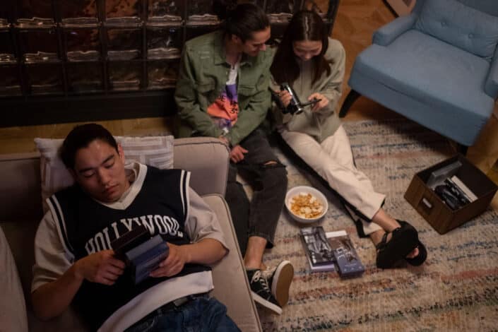 Three people browsing vhs movies collection