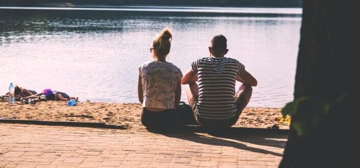 a couple sitting on the sand