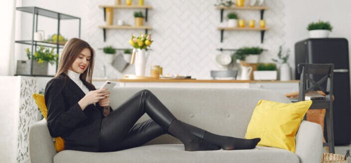 Young woman messaging on smartphone in living room