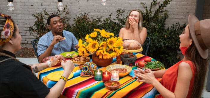 A group of friends laughing while having snacks