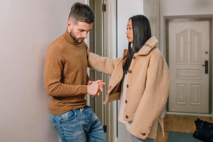 a sad woman touching a mans arm