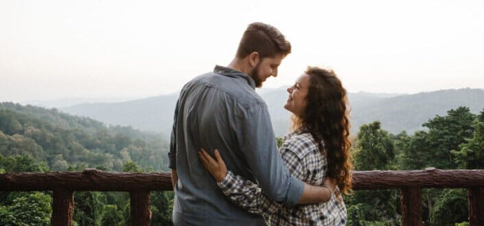 young couple hugging while resting on veranda