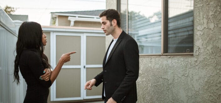 Man standing beside woman in black dress