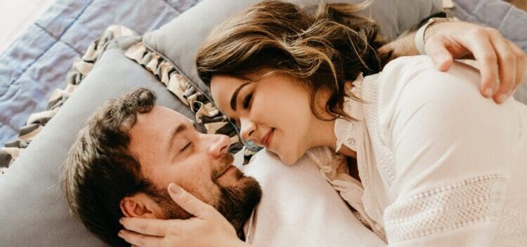 man lying on bed beside his girlfriend
