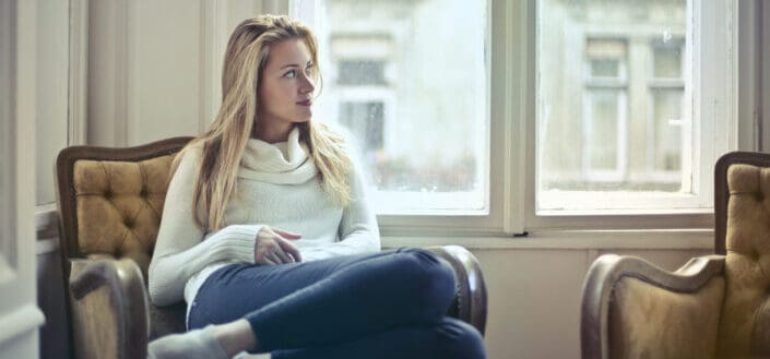 woman sitting on chair near window
