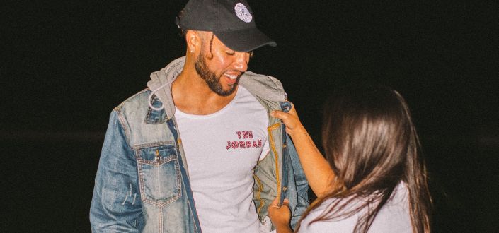 woman taking off man's jacket