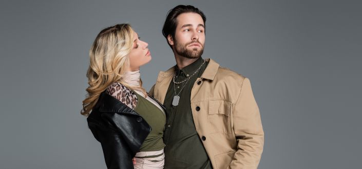 Blonde woman in jacket looking at man