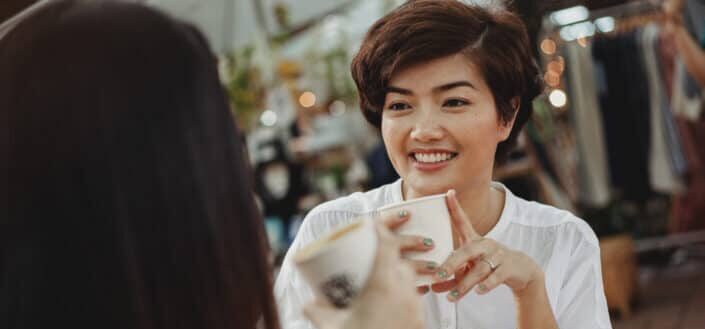 Young women chatting and enjoying hot drinks