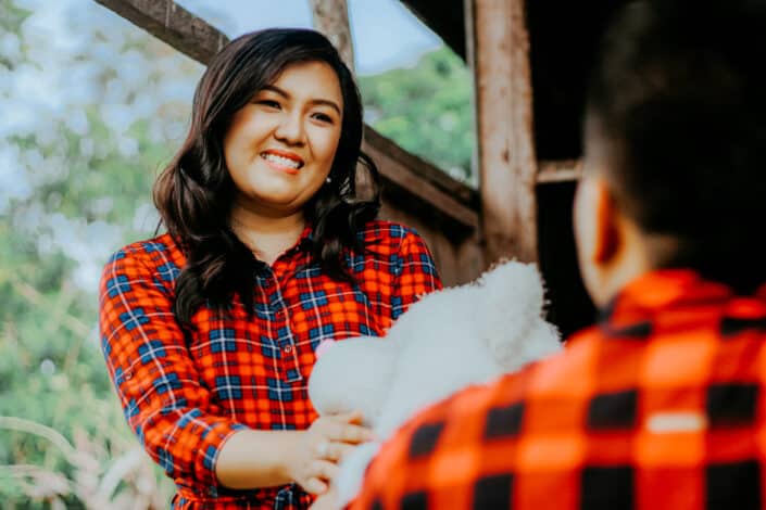 Smiling woman receiving a teddy bear from her boyfriend
