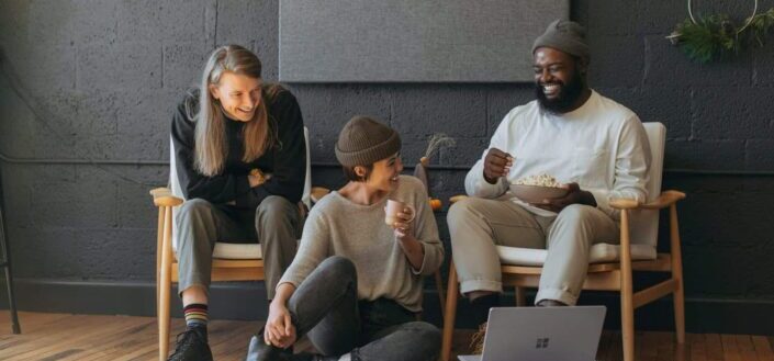 Three Coworkers Sitting Together Laughing