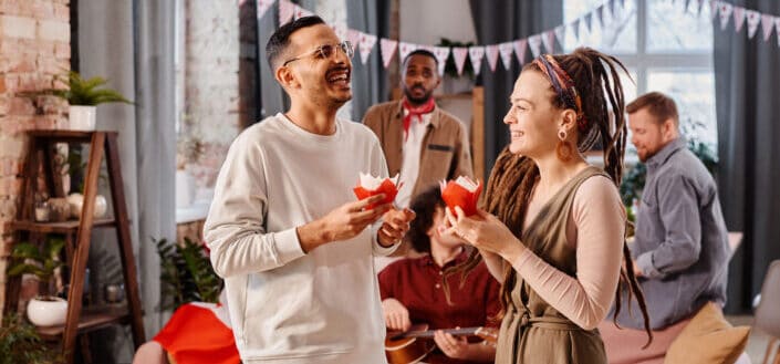 Two friends holding cupcakes in a party