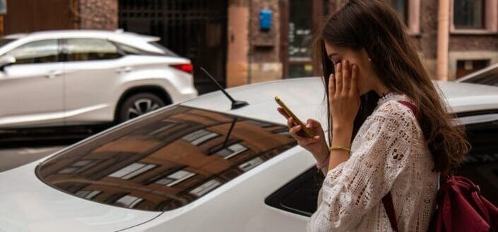 Woman wearing white blouse beside white vehicle