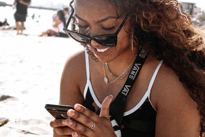 Woman At Beach Using Her Phone