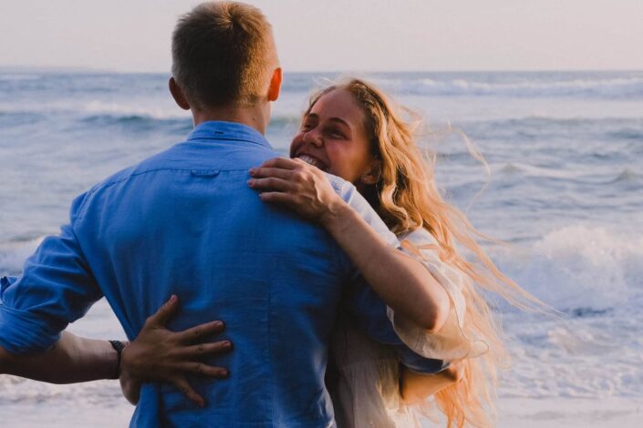 Couple hugging by the beach