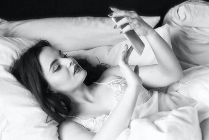 Woman Checking Her Phone While Lying Down