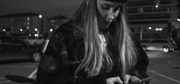 Woman Wearing Knit Cap Holding a Smartphone