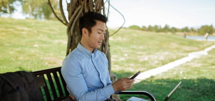 Man in Long Sleeve Shirt Using Cellphone