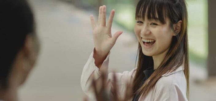Smiling Woman Waving at Her Friends
